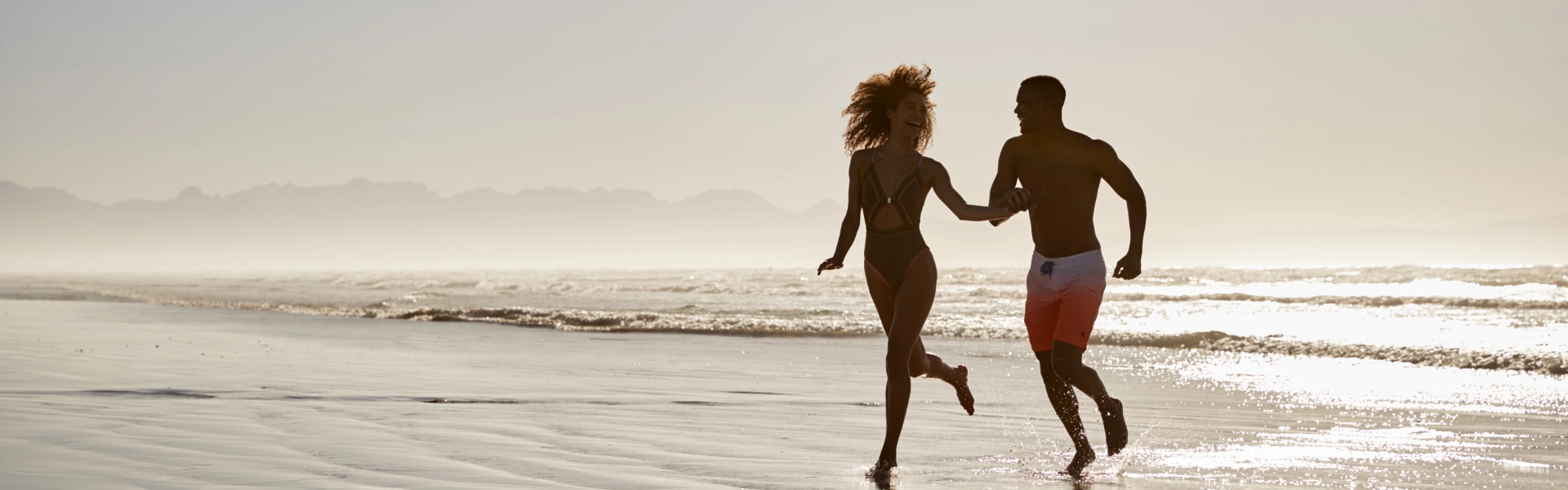 Casal feliz correndo na praia