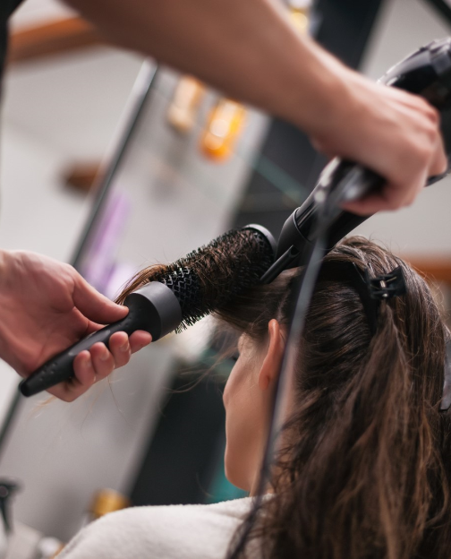 Imagem de uma mulher fazendo escova no cabelo em um dos salões da Posê Beleza